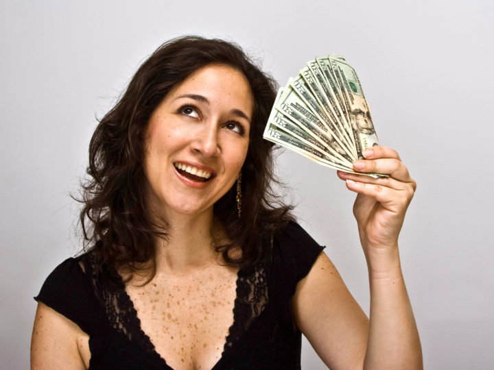 smiling happy woman with a bunch of money, twenty dollar bills